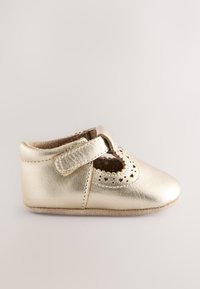 Chaussure bébé en cuir doré avec un bout arrondi, des découpes festonnées et une bride en Velcro pour un maintien sécurisé. Doublure intérieure douce et semelle texturée.