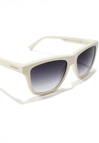 Baltas plastmasas saulesbrilles kaķa acu formā ar gradienta tumšām stikliem. Tām ir plata rāmja un plāni kājiņas, uz sānu daļas redzams "HAWKERS" logotips.