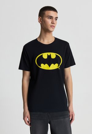 Maglietta nera in cotone con un grande logo giallo di Batman sul davanti. Maniche corte, scollo rotondo e design a vestibilità standard.