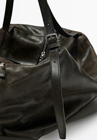 Leather handbag in dark brown with a soft, textured finish. Features a wide strap with a silver buckle and a zippered compartment.