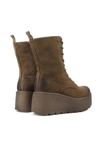 Stivaletti alla caviglia in suede marrone con lacci e suola a piattaforma chunky, caratterizzati da dettagli di cucitura sottili e linguette per una facile vestibilità.