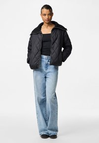 Must mustriga jope laia kraega, kombineeritud helesiniste kõrge vöökoha ja laia jala teksadega. Lihtne disain, mugav lõige ja nähtavad mustrid puuduvad.