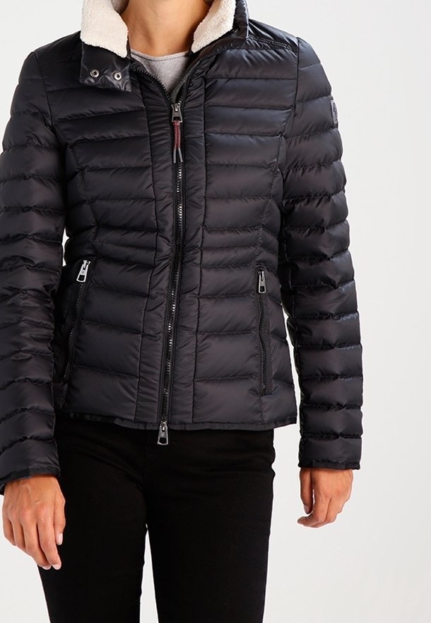 Veste matelassée noire en duvet avec un col montant, une doublure en laine sur le col et des poches zippées à l'avant. Conçue avec un design léger et rembourré.