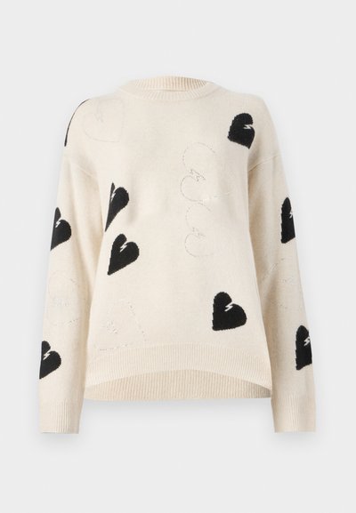 Light beige knit sweater featuring black heart patterns and silver thread accents. Round neck and ribbed hem with loose-fit sleeves.