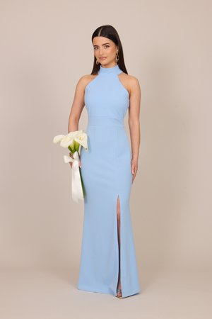Mladá žena v bezrukávových svetlomodrých dlhoch šatách s predným rozparkom, držiaca biele kala zviazané stuhou.