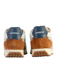 Baskets en suède blanc, bleu et beige avec un design texturé. Marque sur le talon, forme arrondie et semelle en caoutchouc avec un motif circulaire.