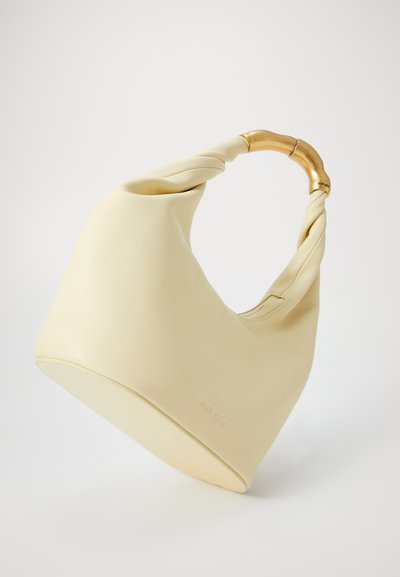Hobo bag in soft, creamy yellow leather with a twisted handle and metal accents. Smooth texture with minimal branding on the side.
