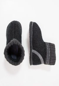 Zwarte gevilte wollen slippers met een gestructureerde buitenkant, grijze accenten en een geribbelde gebreide rand. Vormgegeven voor comfort, gestroomlijnd ontwerp.