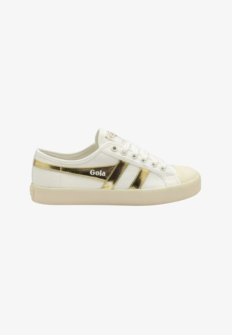 Baskets basses blanches Gola avec semelle beige, avec des bandes métalliques dorées et le logo de la marque sur le côté.