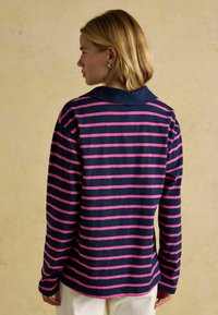 Pikkade varrukatega polo särk tumesiniste ja roosade horisontaalsete triipudega, millel on kontrastne krae ja pehme kangatekstuuri. Näidatakse tagumist vaadet.