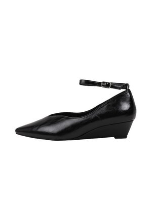 Zapato de cuña de piel negra con puntera puntiaguda, correa delgada en el tobillo y cierre de hebilla.