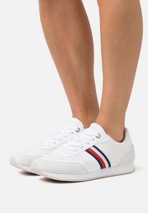 Vita sneakers med mesh och mockamaterial, med en slät yta, röda och marinblå ränder, rundade tår och gummisålar.