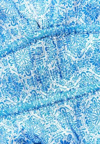 Lekki materiał z niebieskim kwiecistym wzorem na białym tle. Zgromadzona tekstura z detalami szwów.