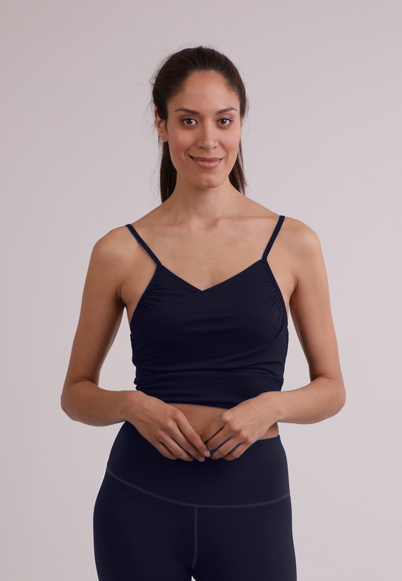 Top fitted blu navy con scollatura a V e spalline sottili, realizzato in un tessuto liscio ed elastico, con un delicato arricciato sul davanti.