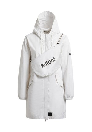 Witte lange jas met capuchon en voorzakken, met een witte crossbody tas met het label "KHUJO 2001" over de borst.