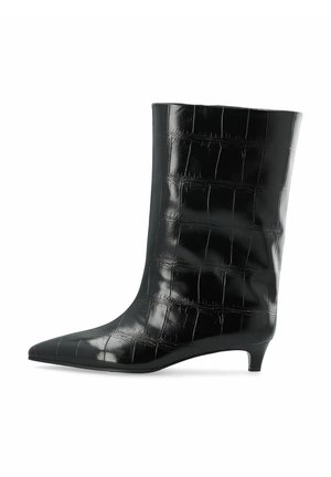 Botte en cuir noire mi-mollet avec texture crocodile, bout pointu et petit talon kitten sur fond blanc.