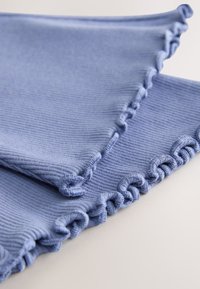 Plavi rebrasti materijal s teksturiranim završetkom, s valovitim rubom i ukrasnim uvijenim šavovima duž rubova.