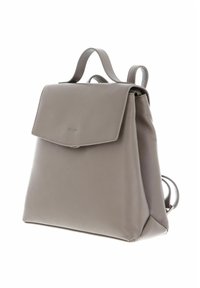Sac à dos en cuir taupe avec une fermeture à rabat, une poignée de transport et des bretelles réglables, présenté sur fond blanc.