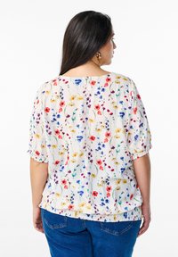 Lille lilledega valge lilleline pluus. Omab erksate punaste, siniste, lilla ja kollaste lillede trüki ning ristusäärist.