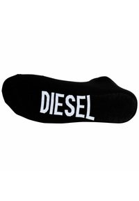 Calcetín de algodón negro con un logo bordado en blanco que dice "DIESEL" en el lado. Textura suave con un diseño de punta redondeada.