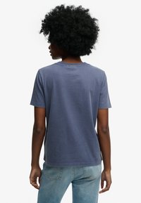 Marineblauw katoenen T-shirt met korte mouwen, ronde hals en een eenvoudig, onopgesmukt ontwerp, gezien vanaf de achterkant.