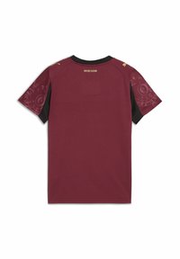 Lyhythihainen maroon urheilu-paita mustilla yksityiskohdilla, jossa on koristeelliset kuviot hihoissa ja kultainen logo kauluksessa.