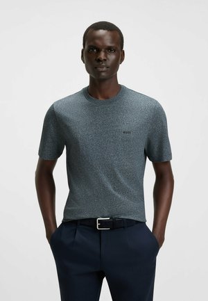 Kurzärmliges T-Shirt mit Rundhalsausschnitt in Dunkelgrau mit einem strukturierten Muster, ausgestattet mit einem kleinen Logo und kombiniert mit dunklen Hosen.