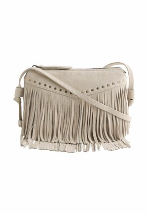 Beige suède crossbodytas met lange franjes en kleine ronde metalen studs langs de bovenrand, ritssluiting en verstelbare band.