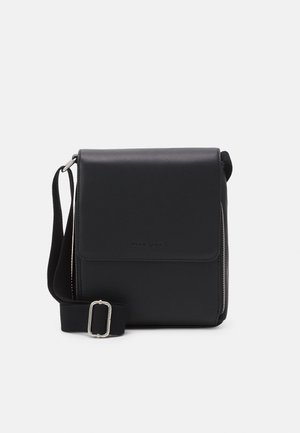 Borsa a tracolla nera in pelle con chiusura a patta, tracolla regolabile, accessori in argento e una texture liscia. Presenta un logo impresso sul davanti.