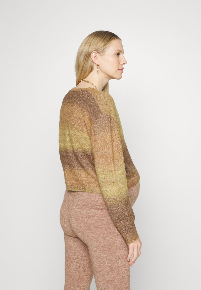 Suéter de malha em tons degradé de castanho e dourado, design cropped, decote redondo, acabamento texturizado. Combinado com calças justas a condizer.