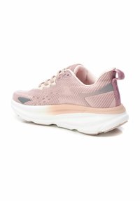 Baskets de course rose clair avec une tige en maille texturée, des accents crémeux, une semelle blanche rembourrée et une languette de talon lavande. Présente des détails réfléchissants.