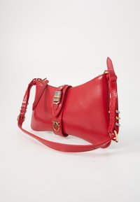 Red leather handbag with a structured shape, gold hardware accents, a detachable strap, and a distinctive clasp featuring parallel lines.