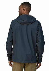 Marine vanntett jakke med hette, elastiske mansjetter, og en nedre kant som strammes for en sikker passform. Glatt tekstur og minimalistisk design.