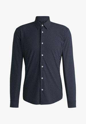 Camicia blu navy con un motivo geometrico bianco, maniche lunghe, colletto a punta e bottoni sulla parte anteriore. Tessuto dalla superficie liscia.