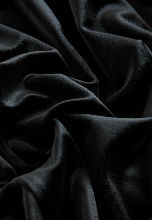 Material de catifea neagră, cu textură moale, având un luciu subtil și pliuri adânci, oferind o aparență bogată și o adâncime luxoasă.