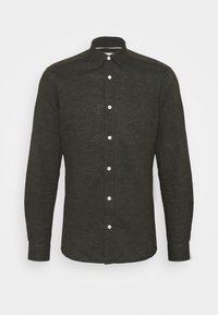 Camicia verde scuro con bottoni, realizzata in tessuto strutturato. Presenta un colletto classico, maniche lunghe e bottoni bianchi sulla parte frontale.