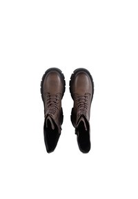 Brown leather combat boots with a round toe, lace-up front, and black rubber sole. Features a high ankle design and reinforced heel.