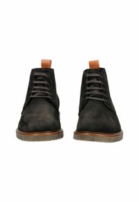 Stivaletti neri in suede alla caviglia con una texture liscia, dotati di accenti in pelle marrone sul tacco e suole in gomma a contrasto. Design classico con lacci.