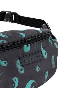 Riñonera negra con patrón yin-yang en turquesa, tela brillante, cremallera frontal y correa ajustable. Presenta el logo de Volcom en la parte frontal.