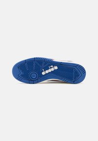 Blue rubber outsole with textured grip pattern; includes a white logo. Upper section features multicolored design with smooth surface.