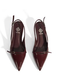 Burgunderfarbene Lackleder Slingback-High Heels mit spitzer Zehenpartie, ausgestattet mit einem dekorativen Riemen und einer Metall-Schnalle. Sanfte Oberfläche, elegantes Design.