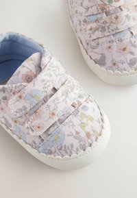 Scarpe con motivo floreale, con tomaia in tessuto rosa pastello che presenta dettagli blu e gialli, fissate con fasce in velcro e con una suola in gomma bianca.