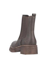 Bottine en cuir marron avec des panneaux latéraux élastiques, un bout arrondi et un talon épais. Dispose d'une semelle texturée et d'un logo sur le talon.