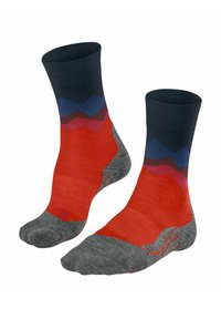 Een paar mid-calf sokken met rode, grijze, zwarte, blauwe, bruine en roze zickzackpatronen op een witte achtergrond.