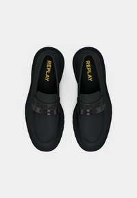 Bottines noires en matière lisse, dotées d'une sangle brillante portant le mot "REPLAY" en lettres majuscules. Semelle extérieure épaisse et texturée.