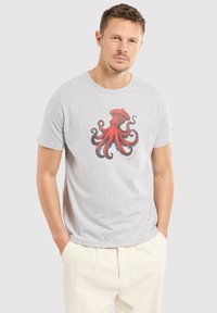 T-shirt en coton gris avec un grand motif de poulpe rouge au centre. Manches courtes et col rond. Coupe décontractée, texture lisse.