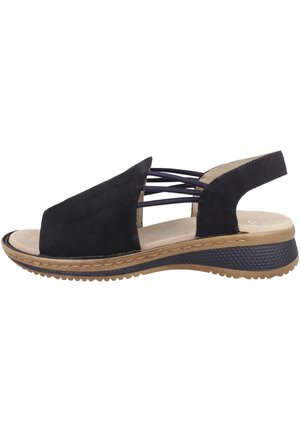 Schwarze Wildledersandalen mit offenem Zeh und überkreuzten oberen Riemen, mit einer beigen Innensohle und einer strukturierten Gummi-Außensohle für besseren Halt.