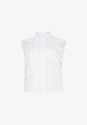 Valkoinen ilmanhiha paita, jossa on klassinen kaulus. Paita sisältää pystysuoria ompelukuvioita ja pieniä koriste-elementtejä ympäriinsä. Napitettava etuosa.