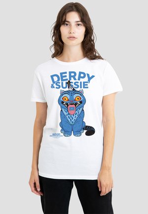 Young woman wearing white T-shirt with colorful cartoon blue cat with wide eyes and tongue out, text "DERPY & SUSSIE" above it.
