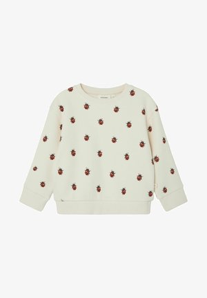 Sweatshirt de couleur crème avec un motif de coccinelle, texture gaufrée, poignets et ourlet côtelés, col rond, et coupe décontractée pour le confort.